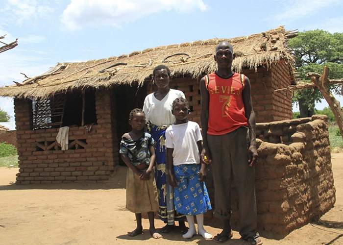 Christina, Austin and two of their children in front of their home. 